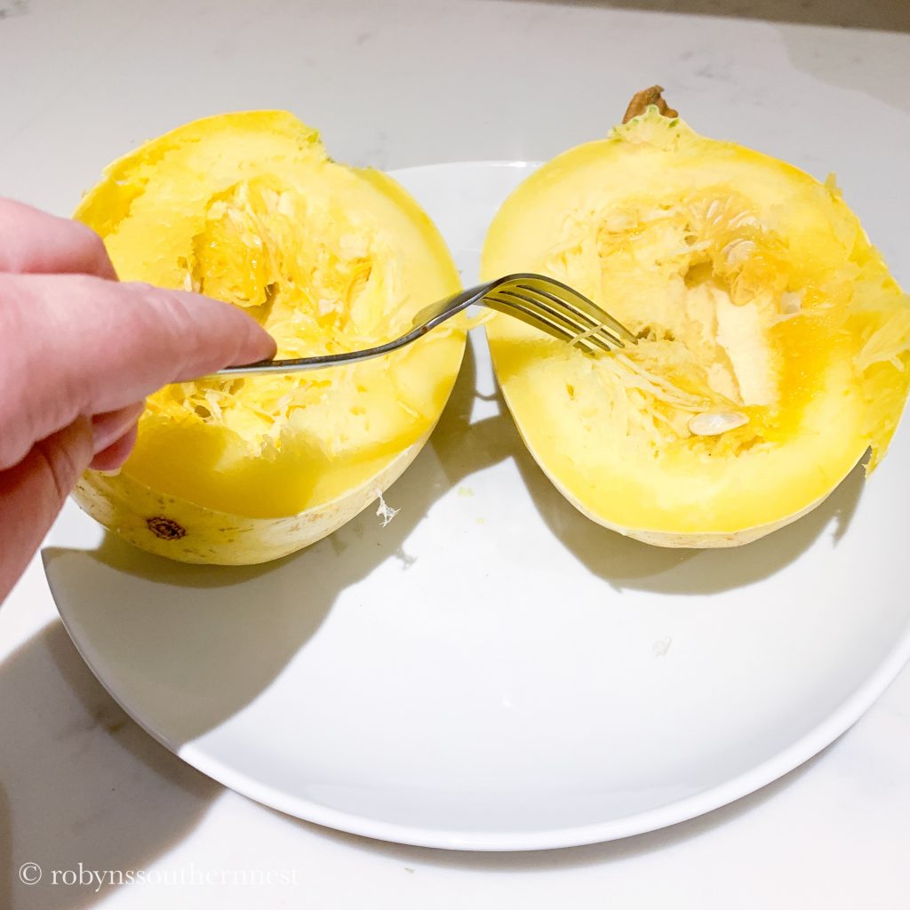 scooping out the seeds of spaghetti squash