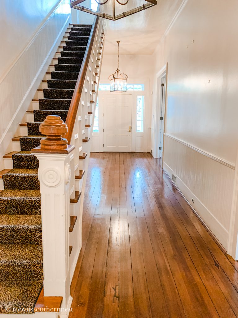 hallway with stairs and leopard runner 